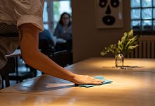 Bedienung säubert einen Tisch im Restaurant - Hannes P Albert/dpa/dpa-tmn