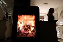 Ein knisternder Holzofen in einem Wohnzimmer - Bernd Wei&szlig;brod/dpa/dpa-tmn