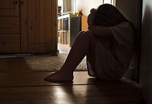 Ein Mädchen sitzt traurig auf dem Boden - Silvia Marks/dpa-tmn