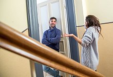 Nachbarn unterhalten sich in einem Hausflur - Christin Klose/dpa-tmn