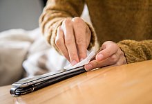 Ein Smartphone wird mit einem Tuch gereinigt - Christin Klose/dpa-tmn