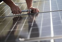 Ein Arbeiter montiert Photovoltaikmodule auf dem Dach eines Wohnhauses. Das Comeback der Solarbranche in Deutschland lockt Investoren an. - Marijan Murat/dpa