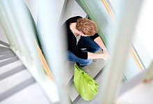 Frau sitzt auf einer Treppe - Peter Steffen/dpa/dpa-tmn