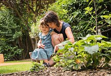 Eine Frau mit einem Kind im Garten - Christin Klose/dpa-tmn