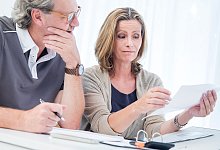 Ehepaar bearbeitet Unterlagen - Christin Klose/dpa-tmn