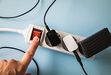 Eine Frau bedient eine Mehrfachsteckdose mit Sicherheitsschalter - Christin Klose/dpa Themendienst/dpa-tmn