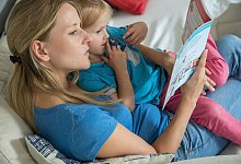 Eine Frau mit einem Kind und einem Buch - Christin Klose/dpa-tmn/dpa