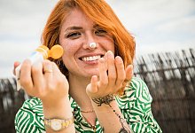 Frau cremt ihr Gesicht mit Sonnencreme ein - Christin Klose/dpa-tmn