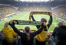 Fans von Dortmund halten ihre Schals nach oben mit Blick auf die S&uuml;dkurve. - Friso Gentsch/dpa