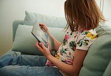 M&auml;dchen schaut auf ein Tablet - Annette Riedl/dpa/dpa-tmn