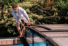 Ein junger Mann deckt einen Pool ab - Zacharie Scheurer/dpa-tmn