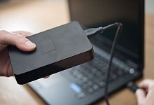 Externe Festplatte wird an einen Laptop angeschlossen - Henrik Josef Boerger/dpa-tmn