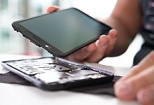 Mann baut ein Smartphone auseinander - Franziska Gabbert/dpa-tmn