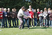 Auf dem Gr&uuml;n: W&auml;hrend die Sch&uuml;ler-Gruppe zusieht, f&uuml;hrt Profi-Golfer Andrew Parker die Arme von Lisa Marie Cilbiyikoglu beim Schlag. - Foto: Gallisch