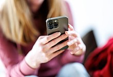 Junge Frau bedient Smartphone - picture alliance / dpa