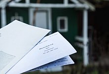 Grundsteuerbescheid von 2025 vor einem Haus(2) - Christin Klose/dpa-tmn