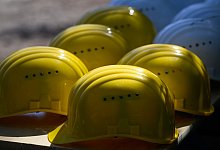 Bauhelme auf einem Tisch - Robert Michael/dpa/dpa-tmn
