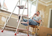 Ein Mann sitzt auf einem Stuhl und telefoniert - Christin Klose/dpa-tmn