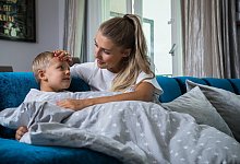 Eine Mutter fasst ihrem Sohn prüfend an die Stirn - Christin Klose/dpa-tmn