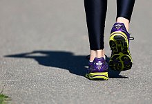 Person in Turnschuhen geht über eine Straße - Nic Bothma/epa/dpa-tmn