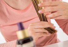 Eine Frau schaut sich ihre Haarspitzen an. - Christin Klose/dpa-tmn