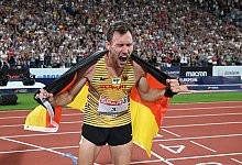 Niklas Kaul feiert mit der deutschen Fahne. - Sven Hoppe/dpa