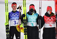 Die deutschen Nordischen Kombinierer Vinzenz Geiger (l-r), Julian Schmid und Manuel Faisst jubeln &uuml;ber die Silbermedaille. - Daniel Karmann/dpa