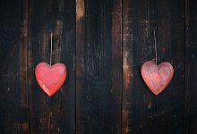 Zwei rote Herzen aus Holz hängen an einem Holztor - Karl-Josef Hildenbrand/dpa/dpa-tmn