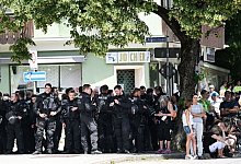Polizisten suchen bei der Kundgebung vor der Demonstration des B&uuml;ndnisses &laquo;Stop G7 Elmau&raquo; Schatten unter einem Baum. - Angelika Warmuth/dpa