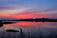 Farbenpr&auml;chtig leuchtet der Morgenhimmel &uuml;ber dem deutsch-polnischen Grenzfluss. - Patrick Pleul/dpa