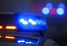 Ein Polizeiauto mit eingeschaltetem Blaulicht steht an einer Unfallstelle. - Karl-Josef Hildenbrand/dpa/Archivbild