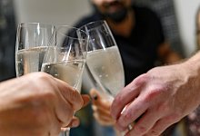 Mehrere Personen halten Sektgläser in den Händen - Daniel Maurer/dpa-tmn