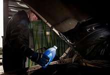 Mann f&uuml;llt Frostschutzkonzentrat in die Scheibenwaschanlage - Klaus-Dietmar Gabbert/dpa-tmn