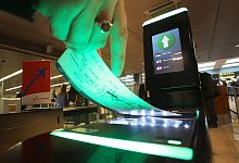 Fluggast geht mit Bordkarte durch die Kontrolle - Christian Charisius/dpa/dpa-tmn