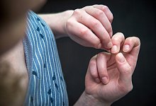 Eine Frau knibbelt an ihren Fingernägeln - Andrea Warnecke/dpa-tmn