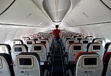 Mann geht durch den Gamg in einem Flugzeug - Klaus-Dietmar Gabbert/dpa-tmn