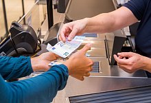 Frau hebt Geld im Supermarkt ab - Benjamin Nolte/dpa-tmn