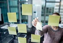 Post-its kleben an einer Scheibe in einem B&uuml;ro - Zacharie Scheurer/dpa-tmn