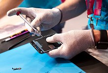 Mann repariert Smartphone - Florian Schuh/dpa-tmn