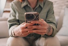 Frau schaut auf ihr Smartphone - Zacharie Scheurer/dpa-tmn