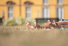 Die nackten Füße zweier Frauen in einem Park - Friso Gentsch/dpa