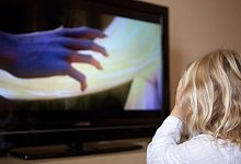 Ein kleines M&auml;dchen schaut einen gruseligen Film - Silvia Marks/dpa-tmn