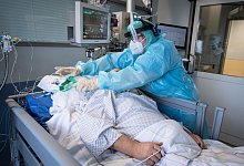 Eine Intensiv-Pflegerin versorgt einen schwer an Corona erkrankten Patienten auf der Intensivstation des Klinikums in Fulda. - Boris Roessler/dpa