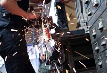 Kunstschmied arbeitet mit einem Winkelschleifer - Christian Charisius/dpa/dpa-tmn