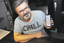 Digitale Technik: Marco Schmidt blickt auf sein Smartphone. Eine App zeigt an, wo sein Audi steht. Der Pin weist aktuell als Standort eine Stadt in Polen aus. - Dieter Scholz