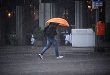 Ein Mann mit Regenschirm im Starkregen - Bernd von Jutrczenka/dpa/dpa-tmn
