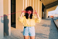 Eine Frau h&auml;lt Schn&uuml;re vor ihr Gesicht - Eugenio Marongiu/Westend61/Eugenio Marongiu/Westend61/dpa