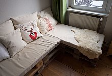 Ein Europalettensofa mit Lammfell und Kissen - Inga Kjer/dpa-tmn