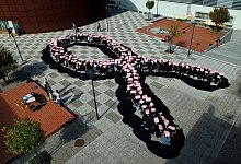 Schüler bilden eine menschliche rosa Schleife - Miguel A. Lopes/dpa