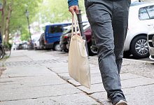 Mann tr&auml;gt seine Einl&auml;ufe in einem Baumwollbeutel - Andrea Warnecke/dpa-tmn